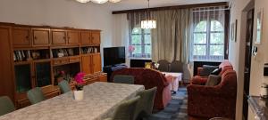 a living room with a table and chairs and a couch at Hársfaapartman és vendégház in Gyula