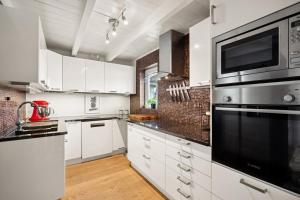 a kitchen with white cabinets and a black appliance at Vinkelgata 20 Guesthouse in Stavanger