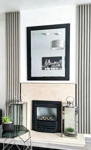 a living room with a fireplace and a mirror at That's Amore House 3 bedroom house with parking walking distance to Sandbach town in Sandbach