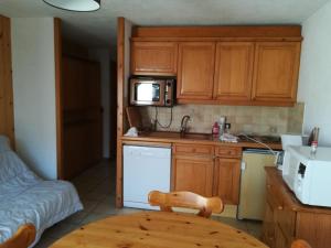 a kitchen with wooden cabinets and a table and a microwave at Nice relax chalet ski m o d e r n in Arâches-la-Frasse