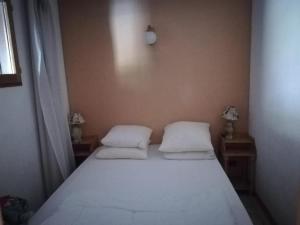 a bedroom with a white bed with two pillows at Nice relax chalet ski m o d e r n in Arâches-la-Frasse