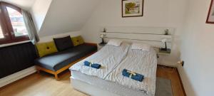 a small bedroom with a bed and a chair at Hársfaapartman és vendégház in Gyula