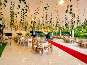 a banquet hall with tables and chairs and a red ribbon at Hotel Campestre Santa Catalina in San Gil +36 photos