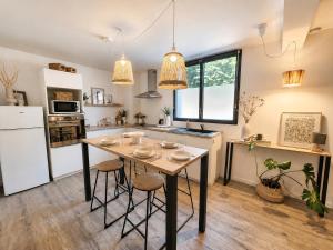 a kitchen with a table and stools in it at Appartement cosy Beaupréau centre in Beaupréau