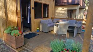 a patio with a table and chairs on a deck at Chata Veverka in Doksy