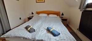 a bedroom with a bed with two pillows on it at Hársfaapartman és vendégház in Gyula +7 photos