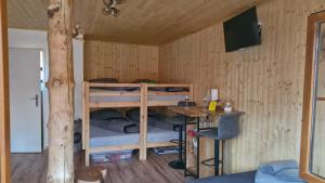a room with two bunk beds and a desk at Chata Veverka in Doksy