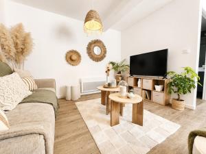 a living room with a couch and a tv at Appartement cosy Beaupréau centre in Beaupréau +2 photos