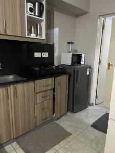 a kitchen with a refrigerator and a microwave at Unique one bedroom with pool in Nairobi