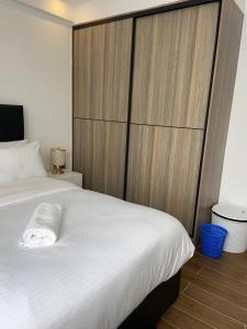 a bedroom with a large white bed with a wooden headboard at Unique one bedroom with pool in Nairobi +8 photos