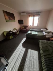 a hotel room with two beds and a window at Dwór Na Otulinie in Białowieża