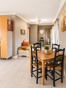 a dining room with a table and chairs and a bed at The Upper Deck Apartment in Swellendam +4 photos
