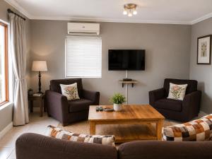 a living room with a couch and a coffee table at The Upper Deck Apartment in Swellendam