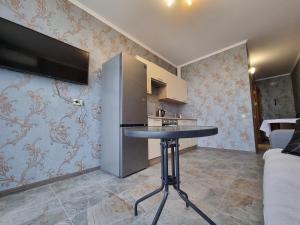 a kitchen with a table and a refrigerator at Панорамний Краєвид на Озеро Позняки Жк Лебединий in Kyiv +7 photos