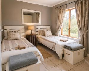 a bedroom with two beds and a mirror at The Upper Deck Apartment in Swellendam