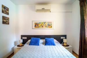 a bedroom with a bed with blue pillows on it at Casa Tati Strand in Sant Pere Pescador +20 photos