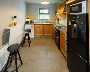 a kitchen with a black refrigerator and a dishwasher at The Tailor's Cottage in Lahinch
