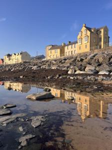a reflection of a building in a body of water at The Tailor's Cottage in Lahinch