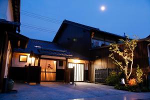 a house with a black roof and a gate at Terakoya Hanatei in Asago
