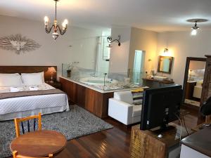 a hotel room with a bed and a tv at Pousada Ouro de Minas in Tiradentes