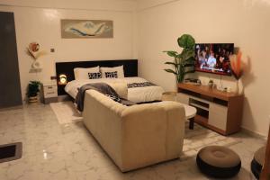 a living room with a couch and a bed at Kilimavista Homes studio D2 in Kimana