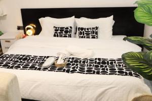 a white bed with black and white sheets and pillows at Kilimavista Homes studio D2 in Kimana