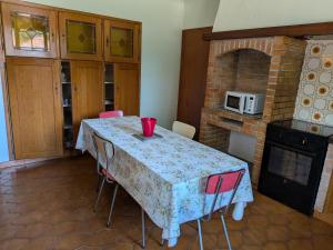 a kitchen with a table with chairs and a microwave at Le Petiou Landais in Soustons