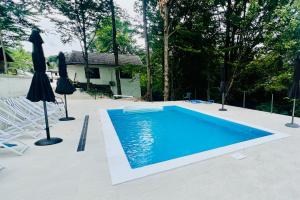a swimming pool with chairs and umbrellas in a yard at Комплекс Света Гора in Oreshak