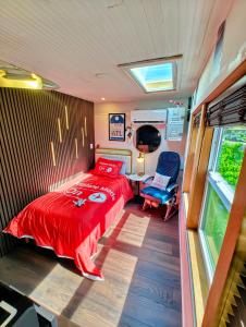a bedroom with a red bed and a window at World Solo Travel's Welcomed At St Pete Home in St. Petersburg