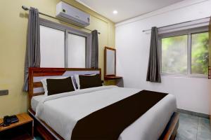 a bedroom with a large bed and a window at Super Collection O Lorven Grand in Visakhapatnam