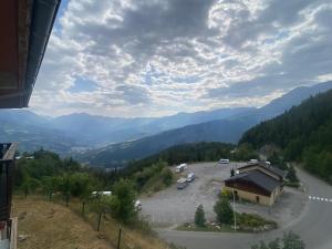 a view of a parking lot with mountains in the background at Praloup1600 in Pra-Loup