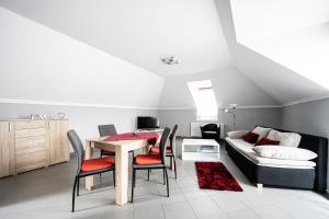 a living room with a table and chairs and a couch at Gere Art&Exclusive Apartments in Harkány