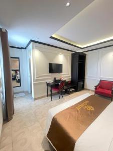 a bedroom with a bed and a desk and a television at Grand Hotel & Spa Bac Ninh in Ðồng Ky