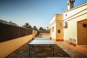 a picnic table in a courtyard next to a building at Casa Tati Strand in Sant Pere Pescador