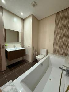 a bathroom with a tub and a toilet and a sink at Triplex résidence tilel chott mariem in Sousse +21 photos