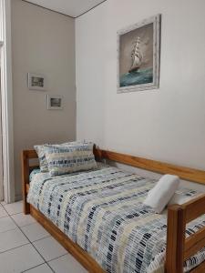 a bedroom with a bed and a picture of a ship at Peacehaven's Top Floor Gem 703 in Scottburgh