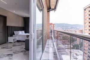 a bedroom with a bed and a balcony at Hotel Colores Estadio in Medellín