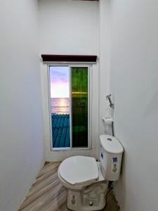 a bathroom with a toilet and a window at Suite frente al Mar con Acceso Directo a la Playa in Ballenita +18 photos