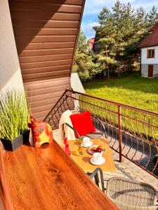 a table on a balcony with a meal on it at Apartament Kułachówka - Sielskie wakacje na wsi, własny sad, pasieka i ogród in Leśnica