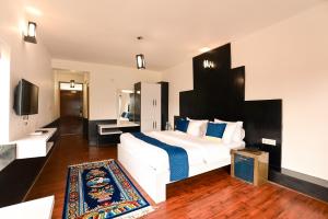 a bedroom with a large white bed and a bathroom at Hotel Karakoram in Leh