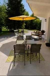 a group of tables and chairs with a yellow umbrella at Logement Seigneur in Rambervillers