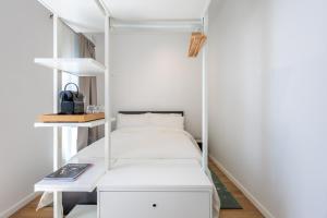 a room with a white bed and shelves at Casa Lola in Mellieħa
