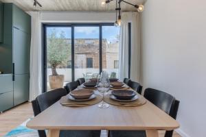 a dining room with a wooden table and black chairs at Casa Lola in Mellieħa