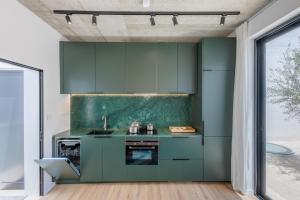 a kitchen with green cabinets and a sink at Casa Lola in Mellieħa