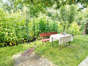 a table and a red bench in a garden at Meronc Mot Guesthouse in Stepʼanavan +2 photos