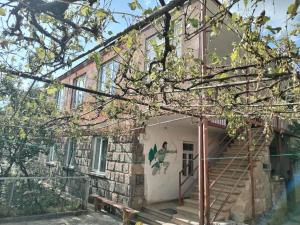 a brick house with a staircase in front of it at Meronc Mot Guesthouse in Stepʼanavan