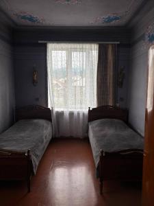 two beds in a room with a window at Meronc Mot Guesthouse in Stepʼanavan
