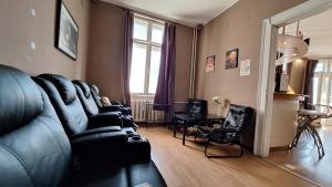 a living room with a black leather couch and a table at Key Hostel Serdika in Sofia