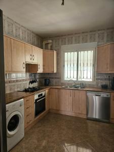 a kitchen with wooden cabinets and a washer and dryer at Villa - Sleeps 4 - Pool - Patio - Parking in Arboleas