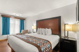 a hotel room with a large bed and a chair at Pine Tree inn in Medford +11 photos